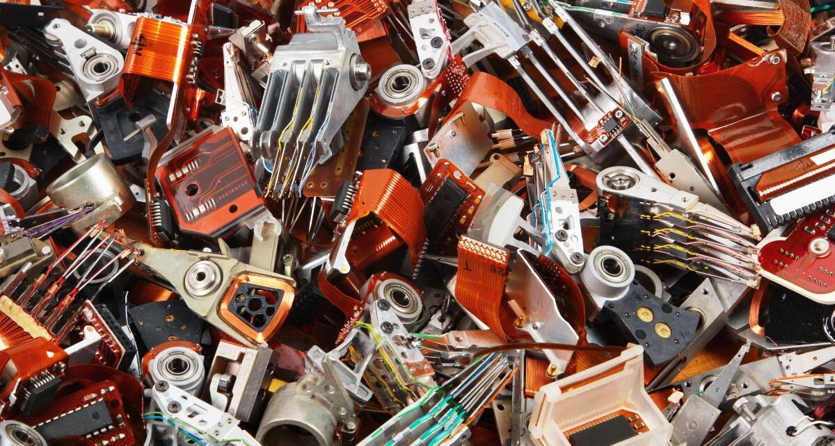 Why Outsource to a Document and Drive Destruction Company? 1 A pile of old parts and components from hard drives that have been torn apart representing e-waste and data destruction.