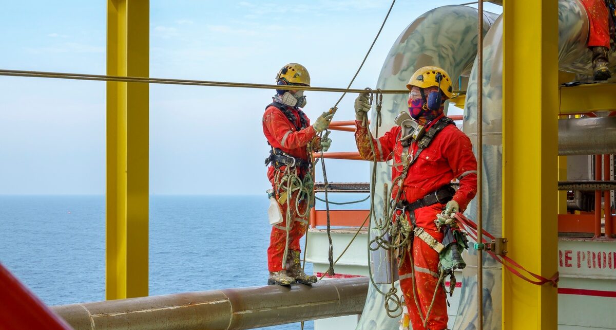 Selecting the Right Rope for Extreme Environments 108 Two workers in orange jumpsuits, face masks, and hard hats work on a pipeline above the ocean, using ropes to secure their safety.
