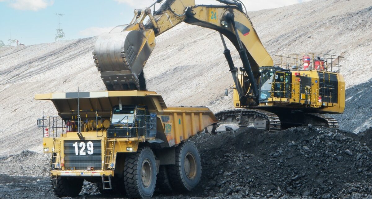 Considerations To Make When Planning Your Mining Project 7 A crane is dropping coal into the bed of a dump truck. The machinery is positioned on a pile of coal.